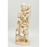 A LARGE JAPANESE MEIJI PERIOD IVORY OKIMONO, of a fisherman standing holding a child in his arms and
