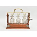 AN EARLY 20TH CENTURY MINIATURE THREE BOTTLE WALNUT AND BRASS TANTALUS, of rectangular outline,