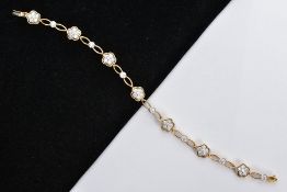 A MODERN 18CT GOLD DIAMOND FLOWER CLUSTER LINK PANEL BRACELET, comprising of seven round clusters