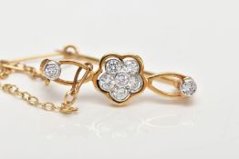 A MODERN DIAMOND BAR BROOCH, centring on a flower cluster of round brilliant cut diamonds, flanked
