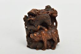 A JAPANESE MEIJI PERIOD CARVED WOOD OKIMONO, depicting a swirl of beasts including a dragon,