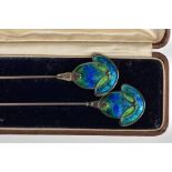 A PAIR OF ART NOUVEAU SILVER AND ENAMEL HATPINS, decorated in blue and green enamel, together with