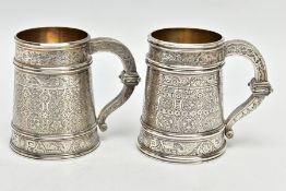 A NEAR PAIR OF LATE VICTORIAN SILVER CHRISTENING MUGS OF CONICAL FORM, PROFUSELY ENGRAVED WITH