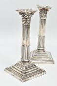 A PAIR OF LATE VICTORIAN SILVER CORINTHIAN COLUMN CANDLESTICKS, both with a shaped square