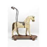 A LATE VICTORIAN CHILD'S PUSH ALONG HORSE, turned wooden handle mounted on an iron frame, the carved