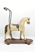 A LATE VICTORIAN CHILD'S PUSH ALONG HORSE, turned wooden handle mounted on an iron frame, the carved