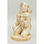 A JAPANESE MEIJI PERIOD IVORY OKIMONO, of a man kneeling, on his back is a performing monkey resting