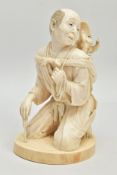 A JAPANESE MEIJI PERIOD IVORY OKIMONO, of a man kneeling, on his back is a performing monkey resting