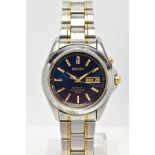 A STAINLESS STEEL SEIKO KINETIC WRISTWATCH, dark blue dial with gold coloured baton markers and