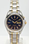 A STAINLESS STEEL SEIKO KINETIC WRISTWATCH, dark blue dial with gold coloured baton markers and