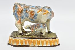 AN EARLY 19TH CENTURY PEARLWARE COW AND CALF GROUP, sponge decorated, on a canted rectangular base