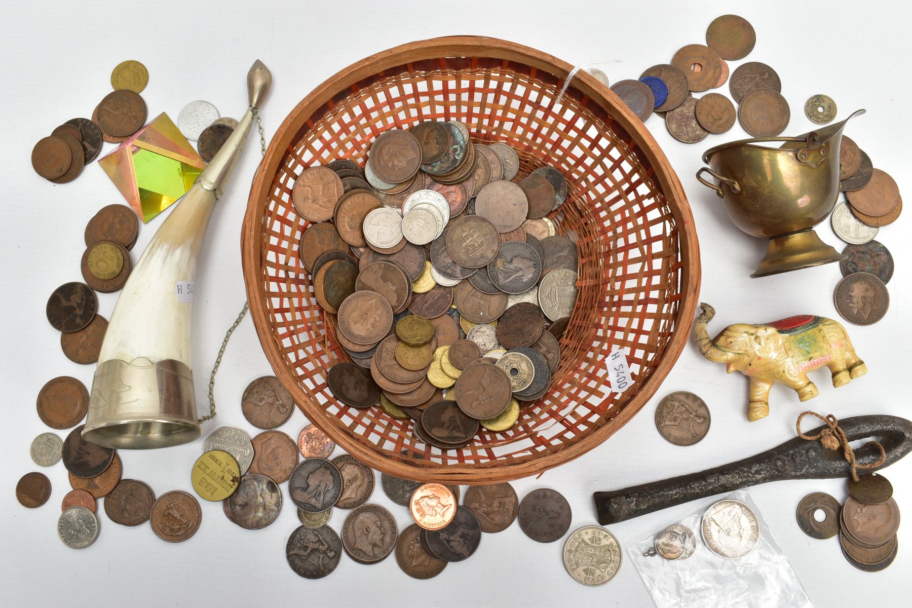 A BASKET OF COINAGE AND OTHER ITEMS, to include a silver South African 2 1/2 shilling coin, 1918