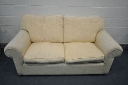A CREAM UPHOLSTERED TWO SEATER SOFA BED