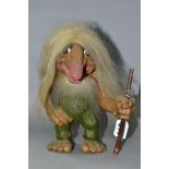 A NORWEGIAN NYFORM TROLL, with hair, beard and furry tail, carrying a stick, height 22cm (