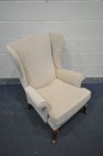 A BEIGE UPHOLSTERED WING BACK ARMCHAIR (no file label, but meets fire regulations)