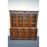 A REPRODUX STYLE MAHOGANY GLAZED FOUR DOOR BOOKCASE, over four drawers and four cupboard doors,