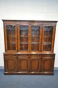 A REPRODUX STYLE MAHOGANY GLAZED FOUR DOOR BOOKCASE, over four drawers and four cupboard doors,