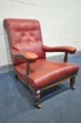 AN EDWARDIAN OAK FRAMED LIBRARY CHAIR, covered in red leatherette upholstery, with a scrolled back