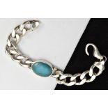A HEAVY SILVER BRACELET, centring on an oval turquoise colour cabochon, bezel set fitted to a wide