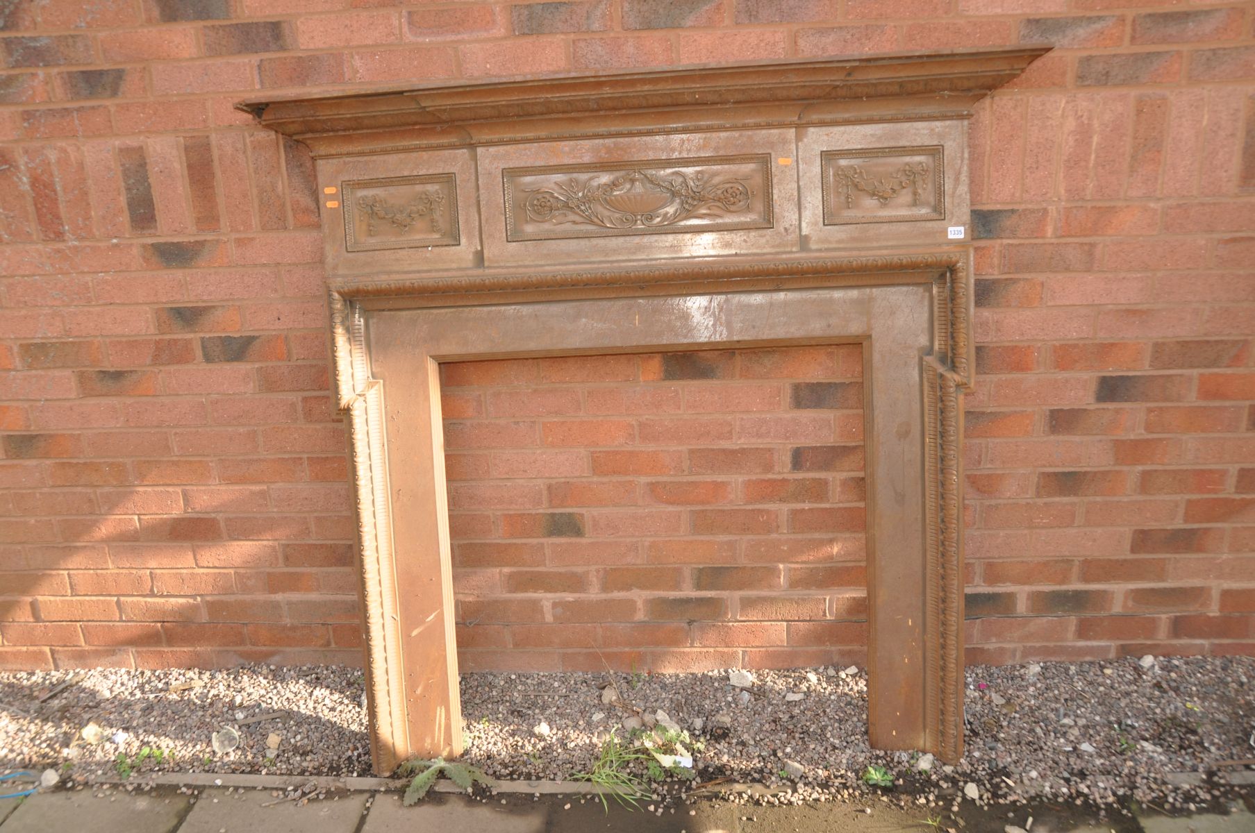 AN EDWARDIAN CAST IRON FIRE SURROUND with rope and swag with foliate detail lozenges to top
