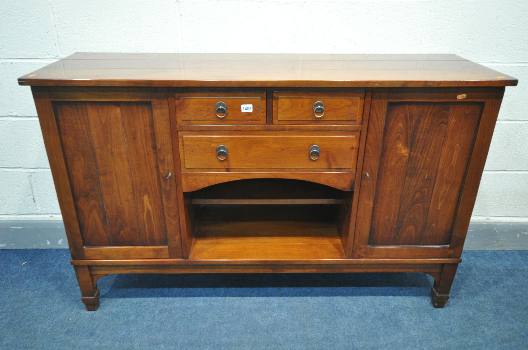 A CHARLES BARR CHERRYWOOD SIDEBOARD, with double cupboard door flanking and arrangement of drawers