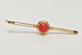 A YELLOW METAL CORAL BAR BROOCH, circular red coral cabochon, approximate width 9mm, set in a yellow