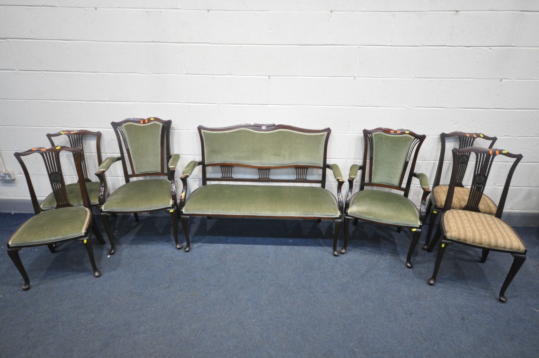 AN EDWARDIAN MAHOGANY SEVEN PIECE SALON SUITE, comprising a sofa with open armrests, length 125cm,