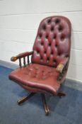 A MAHOGANY OXBLOOD BUTTONED LEATHER SWIVEL OFFICE CHAIR (condition:-frame finish worn in places)