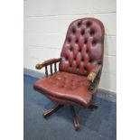 A MAHOGANY OXBLOOD BUTTONED LEATHER SWIVEL OFFICE CHAIR (condition:-frame finish worn in places)