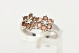 A 9CT WHITE GOLD, GEM SET RING, designed as two flowers set with a central colourless stone each