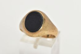 A GENTS 9CT GOLD SIGNET RING, of an oval form set with an onyx panel to a plain polished mount and