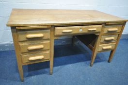 A MID 20TH CENTURY OAK KNEE HOLE DESK, with seven various drawers and two brushing slides, width