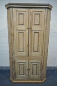 A LARGE 19TH CENTURY PINE CORNER CUPBOARD, with four panelled cupboard, width 124cm x depth 77cm x