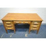 A MID 20TH CENTURY OAK KNEE HOLE DESK, with seven various drawers and two brushing slides, width