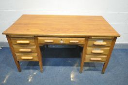 A MID 20TH CENTURY OAK KNEE HOLE DESK, with seven various drawers and two brushing slides, width