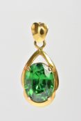 A YELLOW METAL GEM SET PENDANT, centring on an oval cut green stone assessed as chrome diopside,