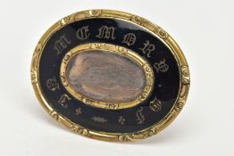 A VICTORIAN MOURNING BROOCH, an oval yellow metal brooch, black enamel with gold writing 'IN