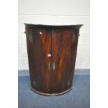 A GEORGIAN MAHOGANY BOWFRONT HANGING CORNER CUPBOARD (condition:-some beading loose, but not