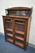 AN EDWARDIAN WALNUT BOOKCASE, with a raised mirrored shelf back, over double glazed doors, enclosing