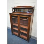 AN EDWARDIAN WALNUT BOOKCASE, with a raised mirrored shelf back, over double glazed doors, enclosing