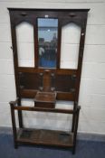 AN EARLY 20TH CENTURY OAK HALL STAND, with four coat hooks (one broken) a single central mirror
