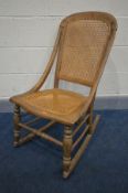 A 19TH CENTURY BEECH ROCKING CHAIR, with bergere back and seat (condition:- some faults and