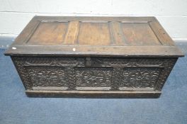 A CHARLES II OAK COFFER, the hinged top with recessed panelling, and carved front and sides, width