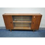 A MID-CENTURY TEAK BOOKCASE, with two cupboard doors flanking a glazed double door section, on