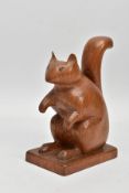 AN EARLY 20TH CENTURY CARVED FOLK ART OAK SQUIRREL, standing 17cm high on a square base, 11.5cm long