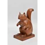 AN EARLY 20TH CENTURY CARVED FOLK ART OAK SQUIRREL, standing 17cm high on a square base, 11.5cm long