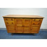 A 1950'S ERCOL ELM SIDEBOARD, with an arrangement of drawers, and cupboard doors, on turned legs