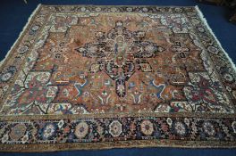 A 20TH CENTURY WOOLLEN HEREZ STYLE RUG, central medallion withing a russet coloured field, and multi