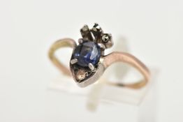 A YELLOW METAL RING, designed as a crown set with a central cushion cut blue stone, with marcasite