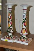 A PAIR OF WEMYSS WARE CANDLESTICKS, painted with an apple design and red/pink rims, circular drip
